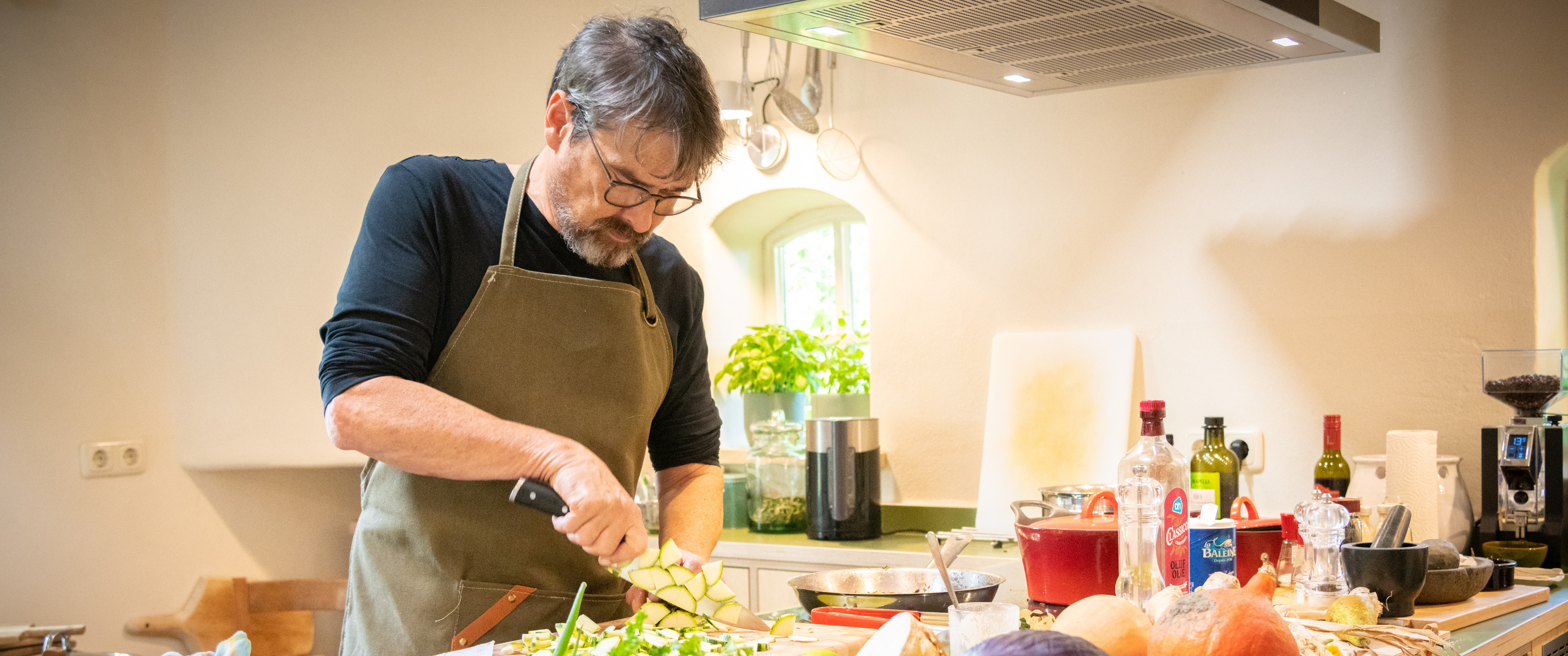 Armand bereidt verse groenten in de keuken van Proeftuin Rottum
